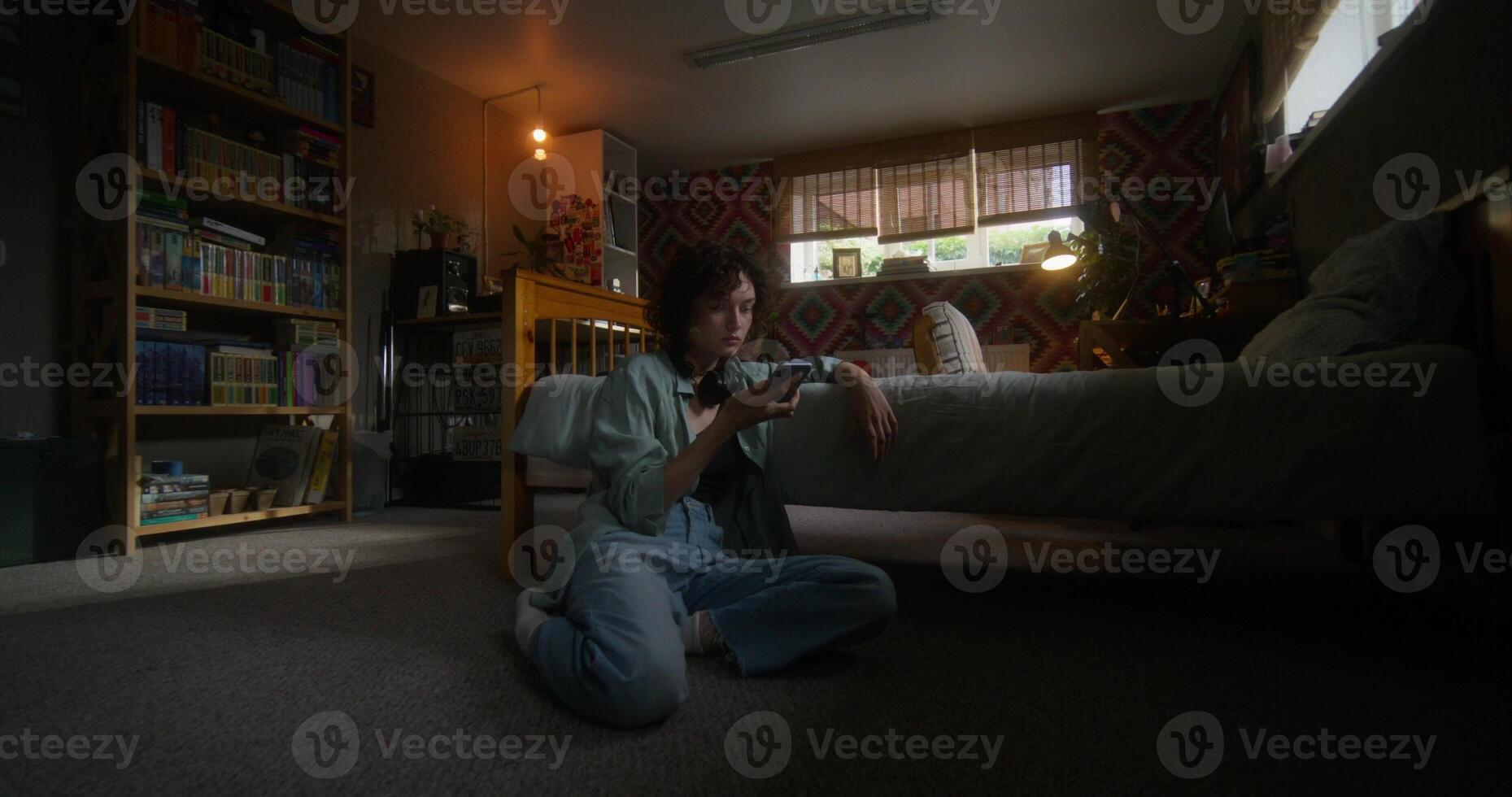 A woman sitting on the floor holding a remote control photo