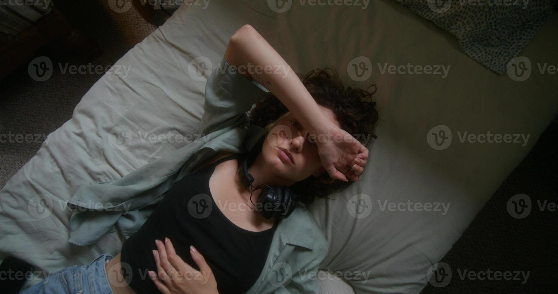 A woman laying on a bed with her head on her hand photo