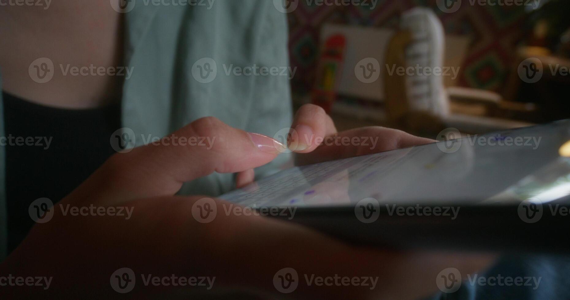 A person holding a tablet computer with a finger on the screen photo