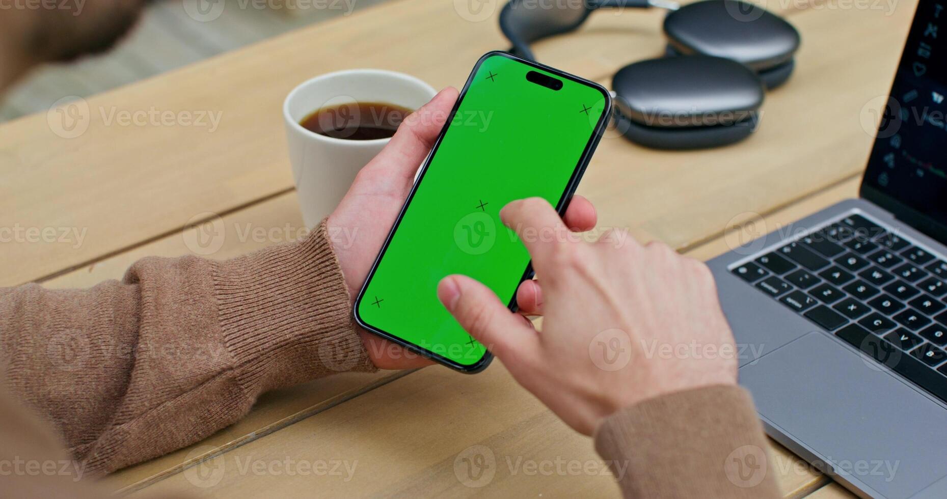 Man using laptop with green screen on desk photo