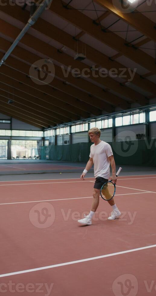 A man and woman shake hands over a stretched net in the middle of a tennis court photo