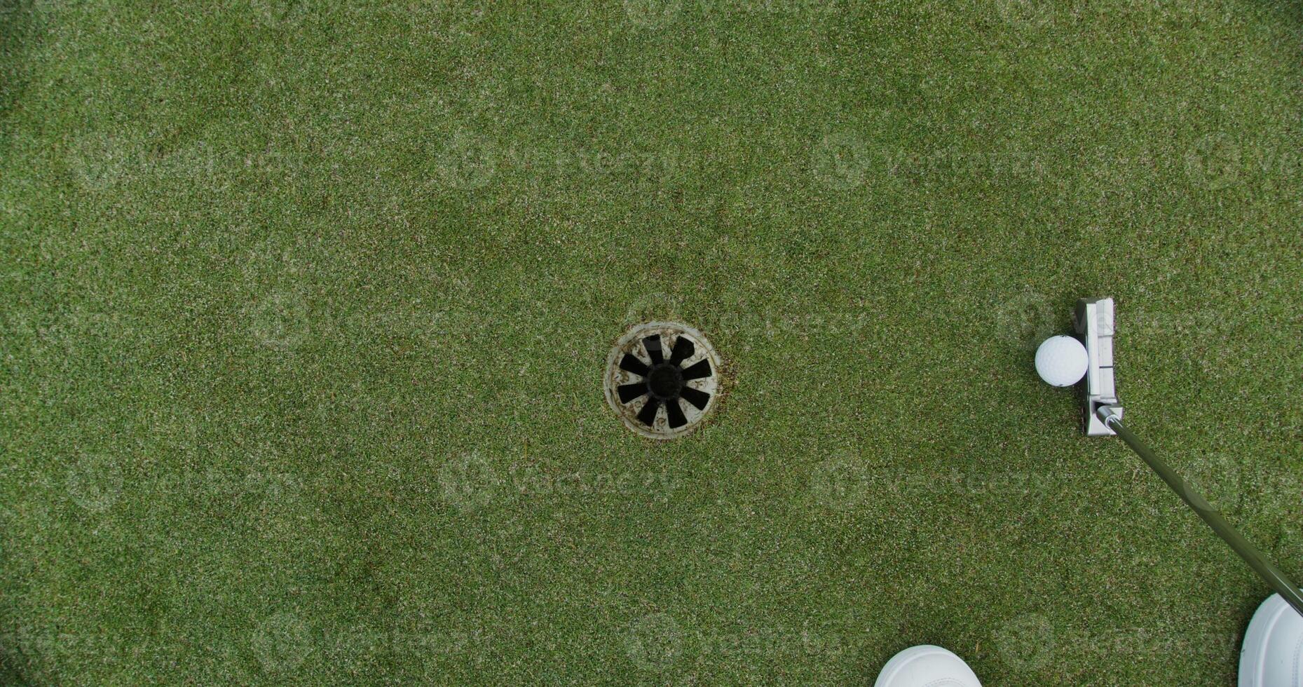 A man hits a ball with a golf club and it hits the target photo