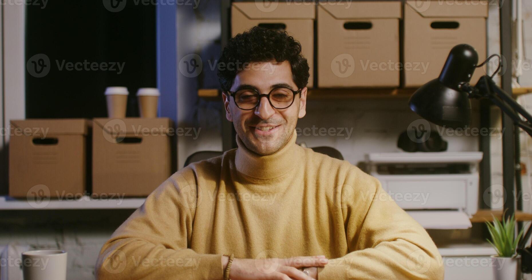 Young man starts a chat looking directly at the camera and smiling photo