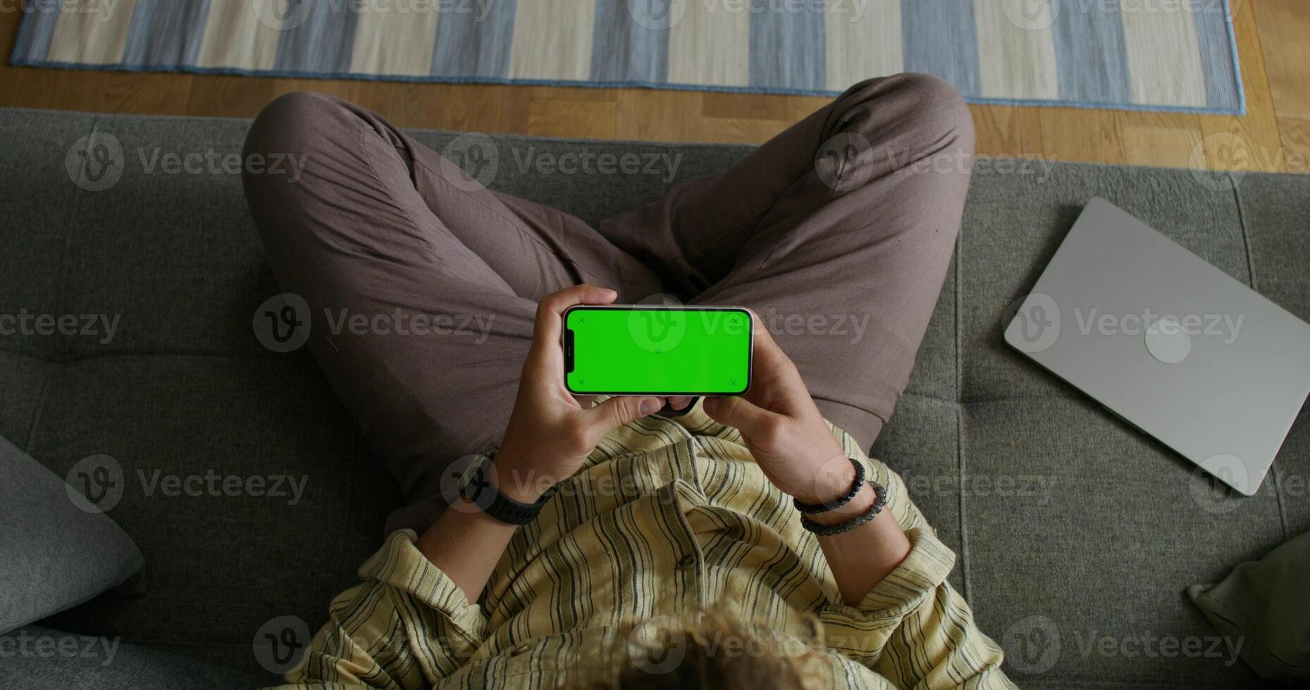 Man using laptop and tablet with green screen in sofa photo
