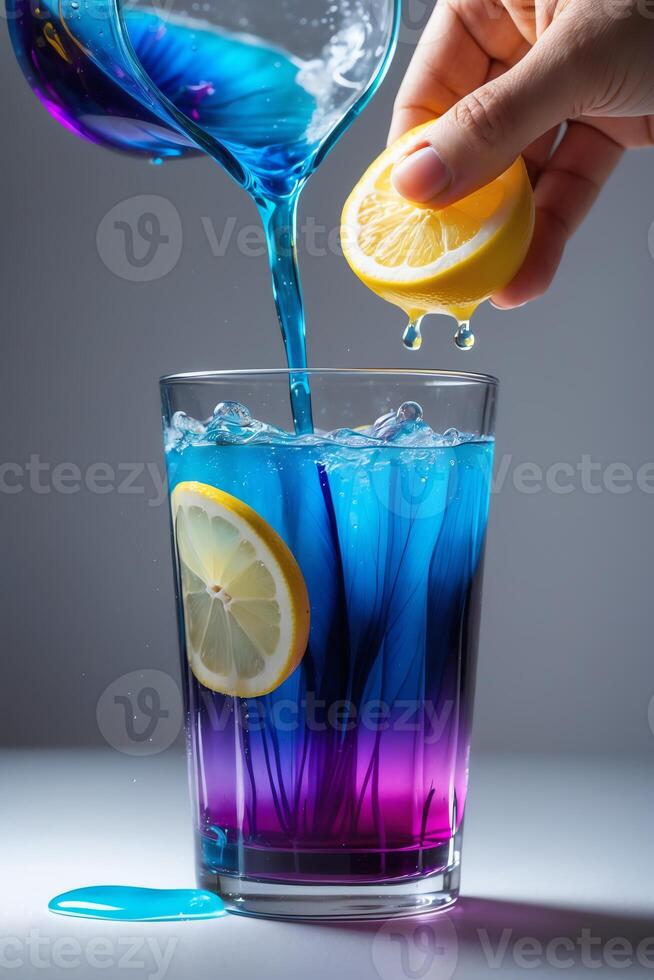 A vibrant drink is being prepared with blue and purple hues, garnished with lemon slices. photo