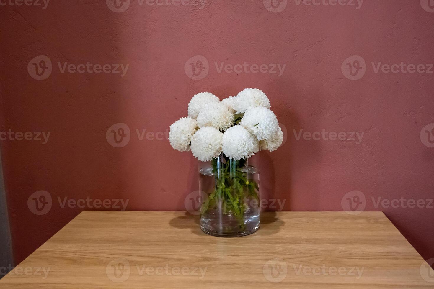 A vase of white flowers on a table photo