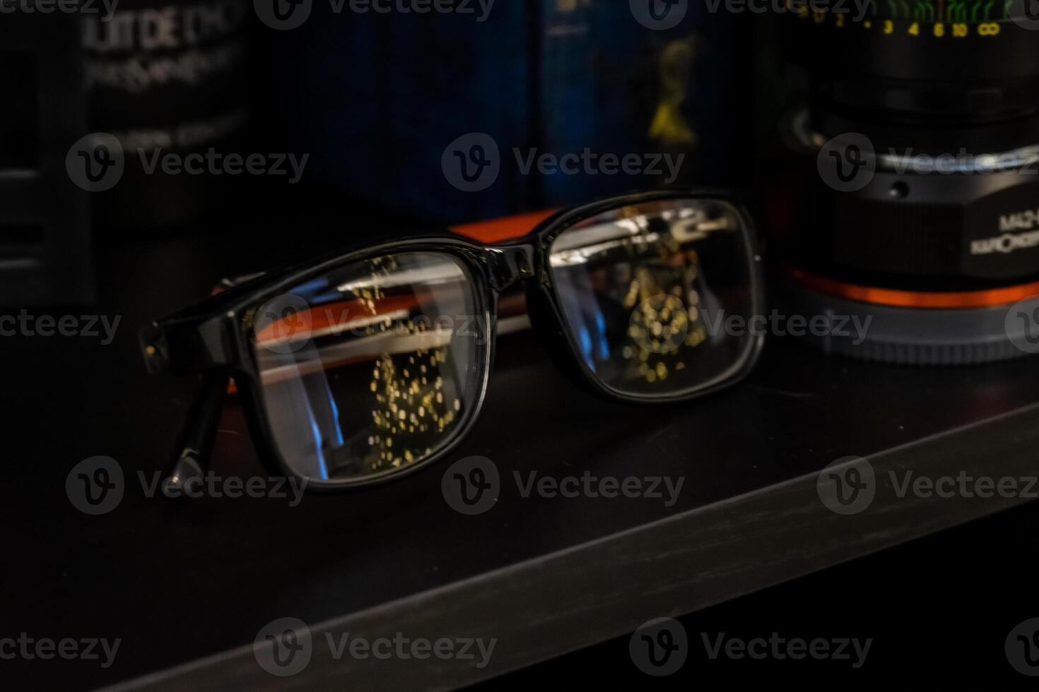 A pair of glasses and a camera on a shelf photo
