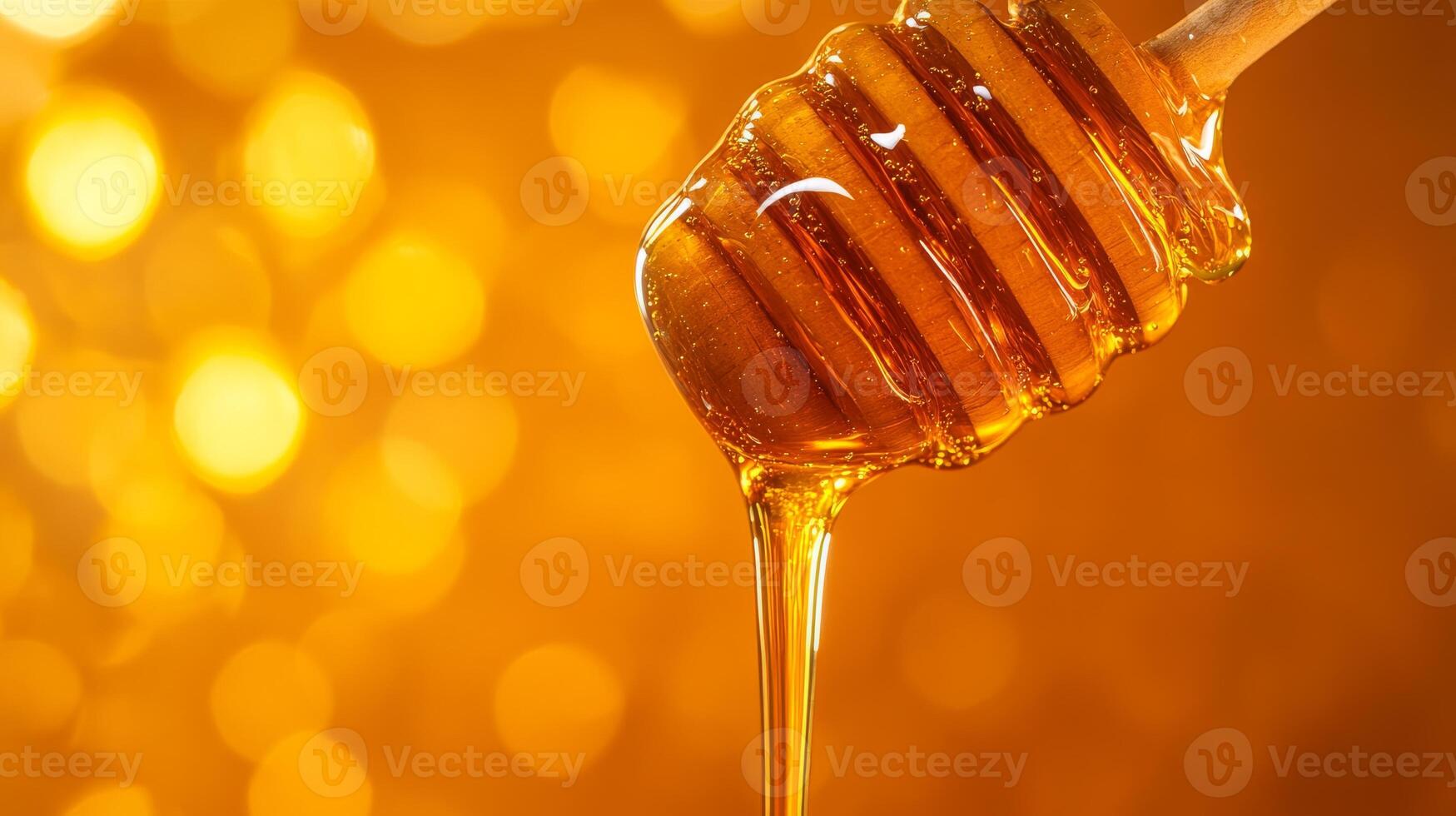 Golden honey dripping from wooden dipper with bokeh background photo