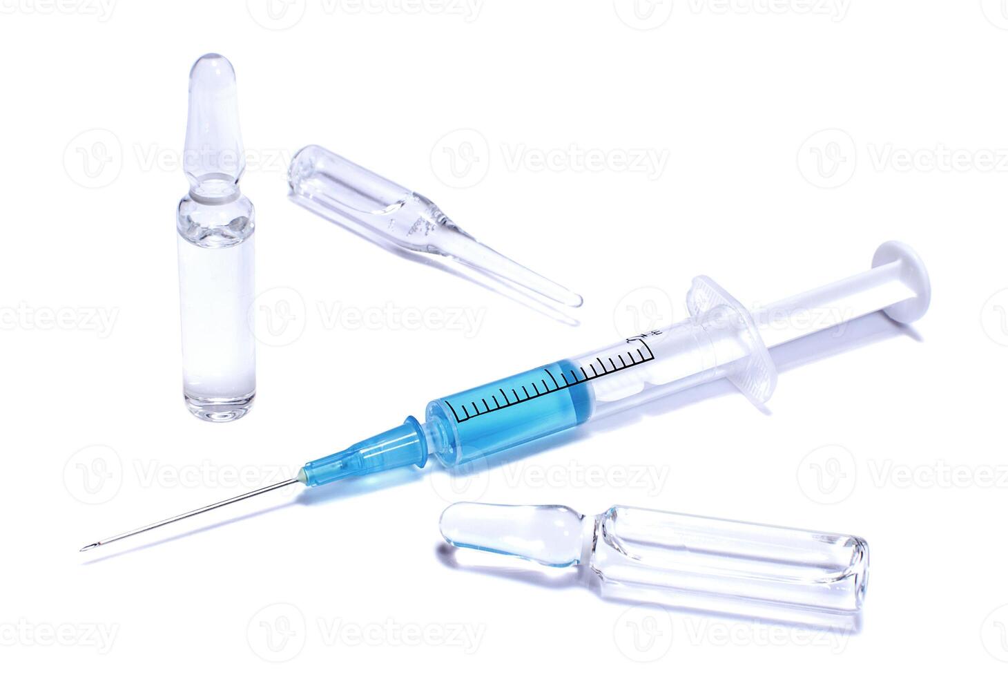 Ampules and syringe with blue vaccine photo
