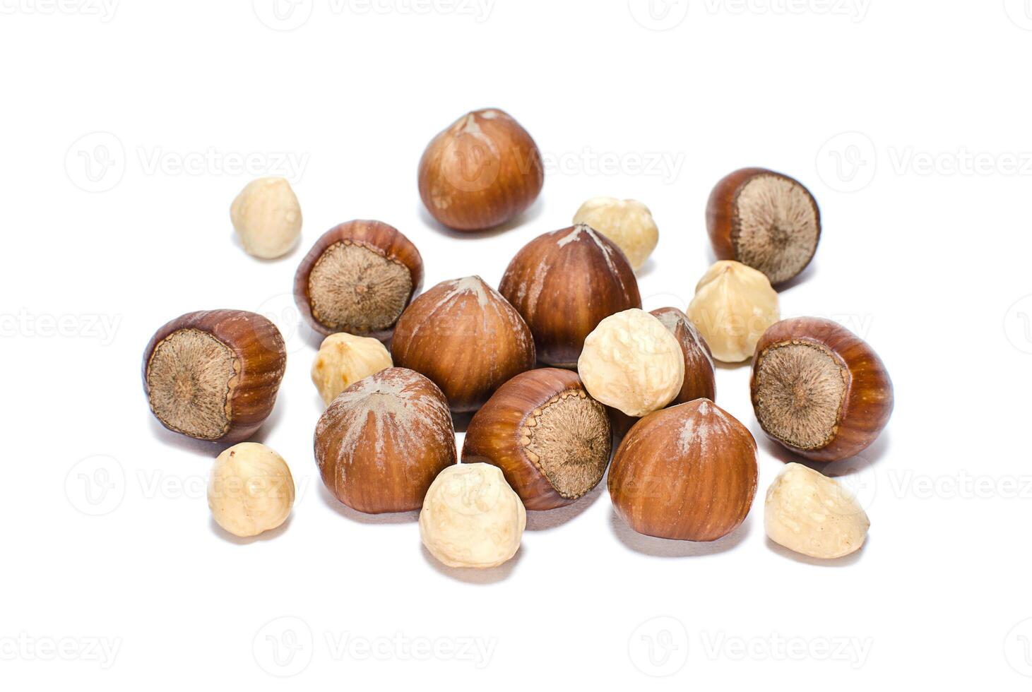 Whole and peeled hazelnuts isolated on white photo