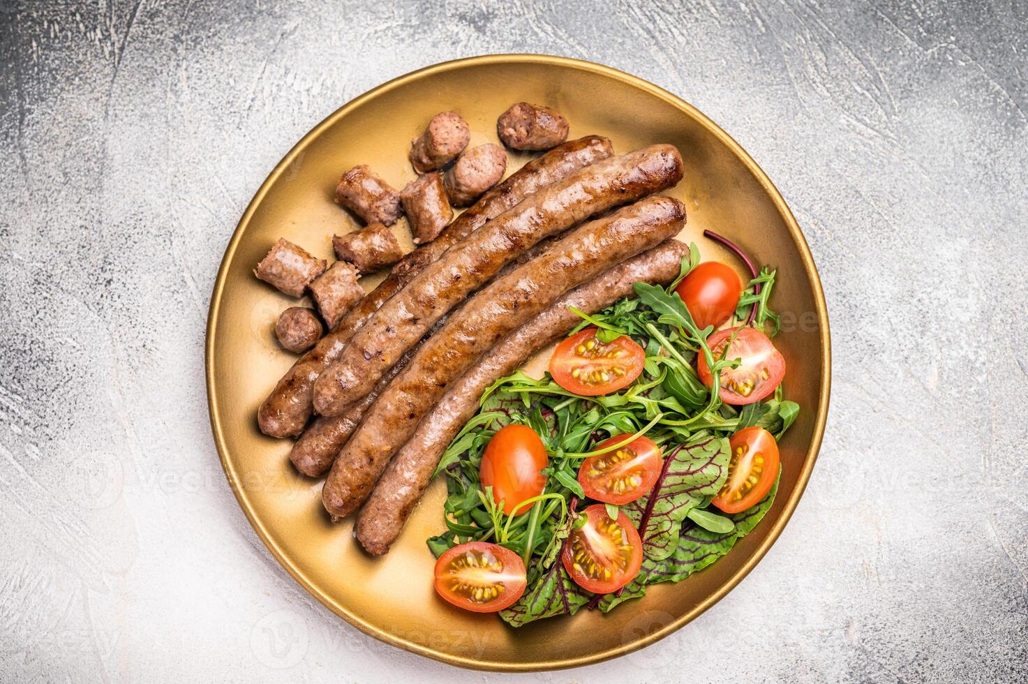 Close up of perfectly charred grilled sausage with salad, ideal for adding flavor to your favorite dishes or sandwiches. white background. top view photo