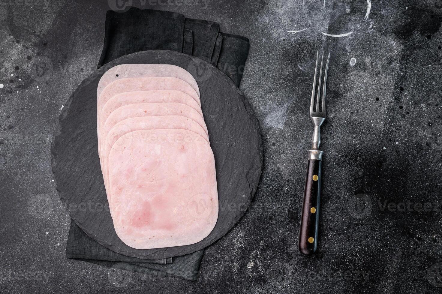 Thinly sliced ham arranged beautifully, perfect for sandwiches, charcuterie boards, or gourmet meals. black background. top view photo