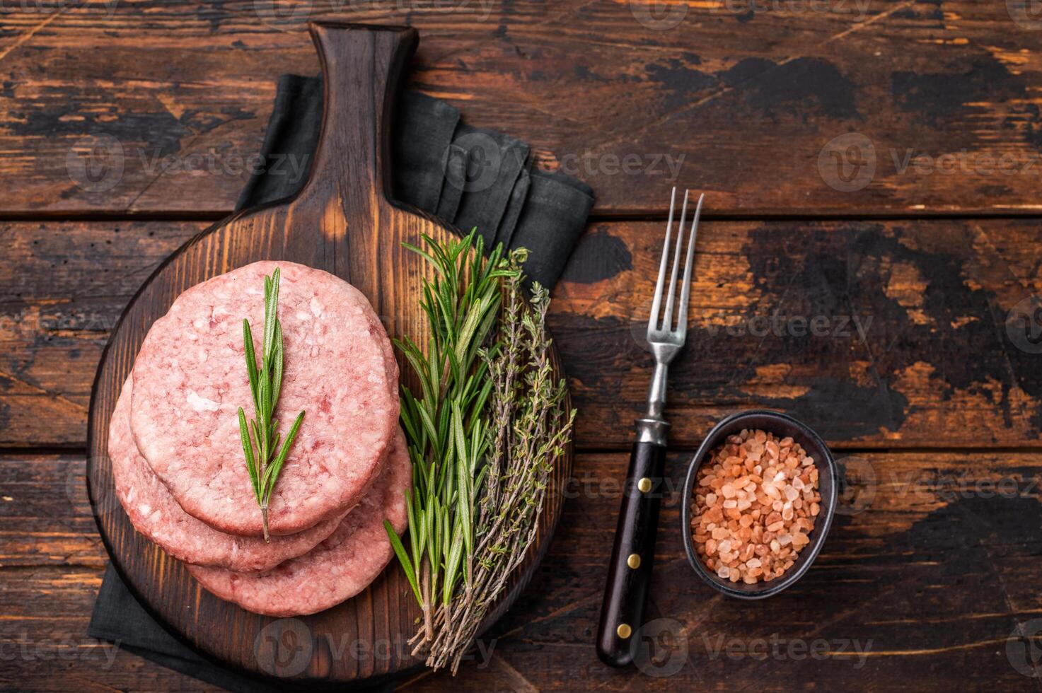 Uncooked beef and pork meat patty on a wooden board, inviting you to create your favorite gourmet burger recipes. wooden background. top view photo