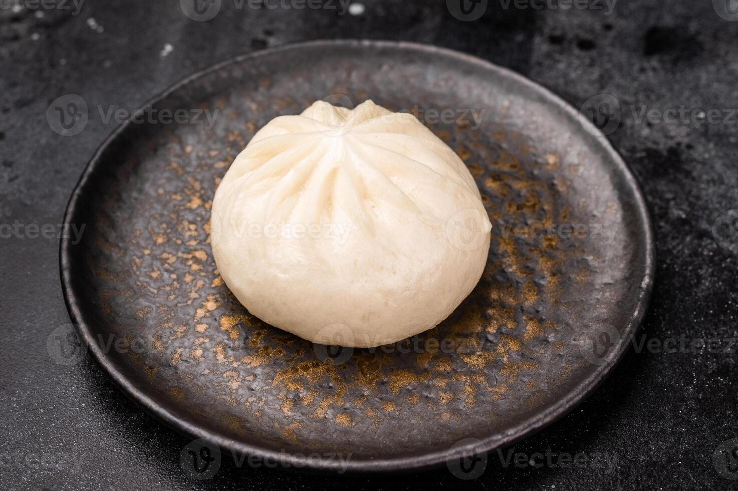 Steam Bao bun with meat on plate with chopsticks. black background. top view photo