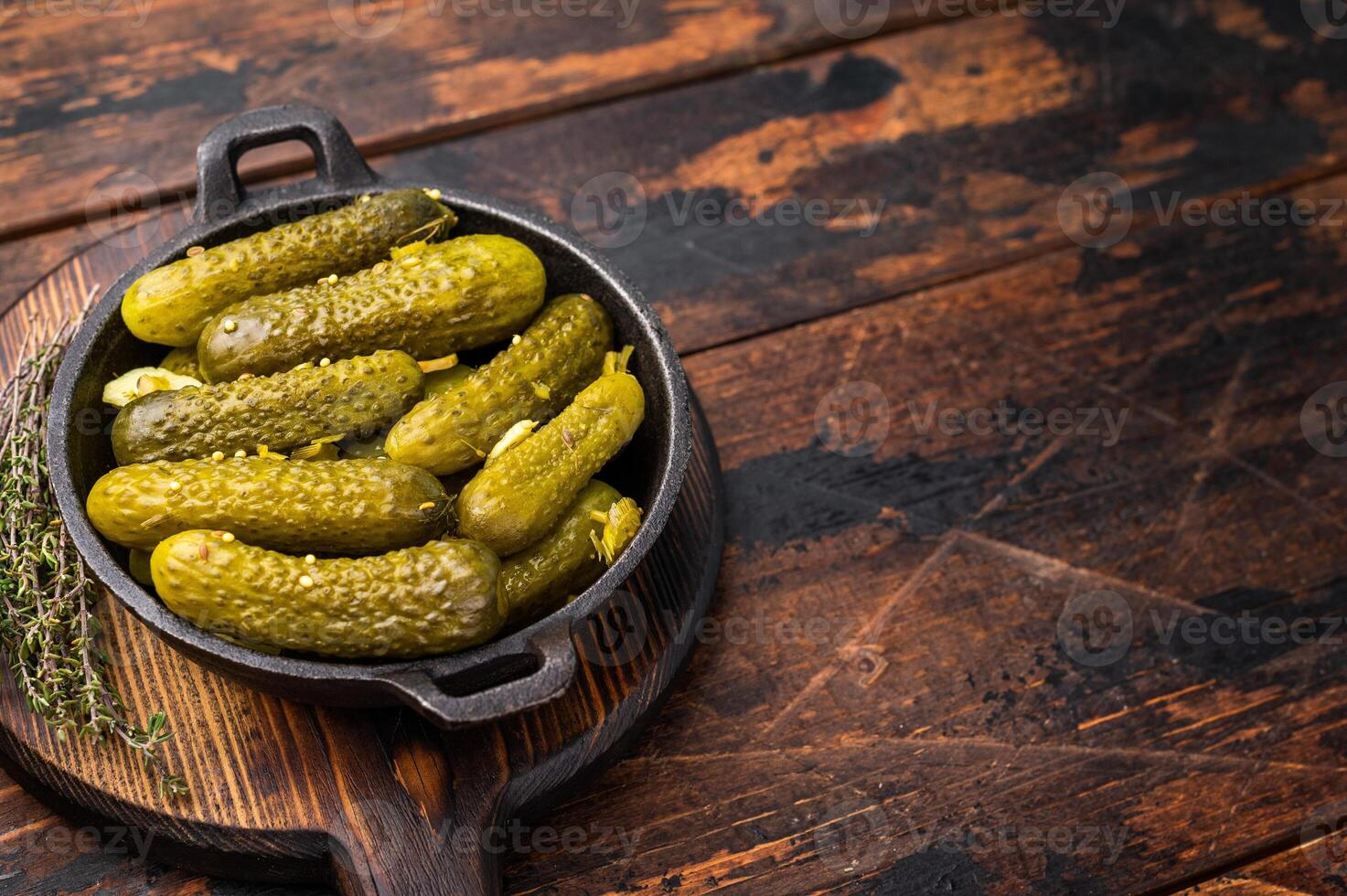 Artisan Pickled Gherkins, pickled cucumbers, beautifully arranged and ready to elevate your culinary creations with their bold taste. wooden background. top view photo