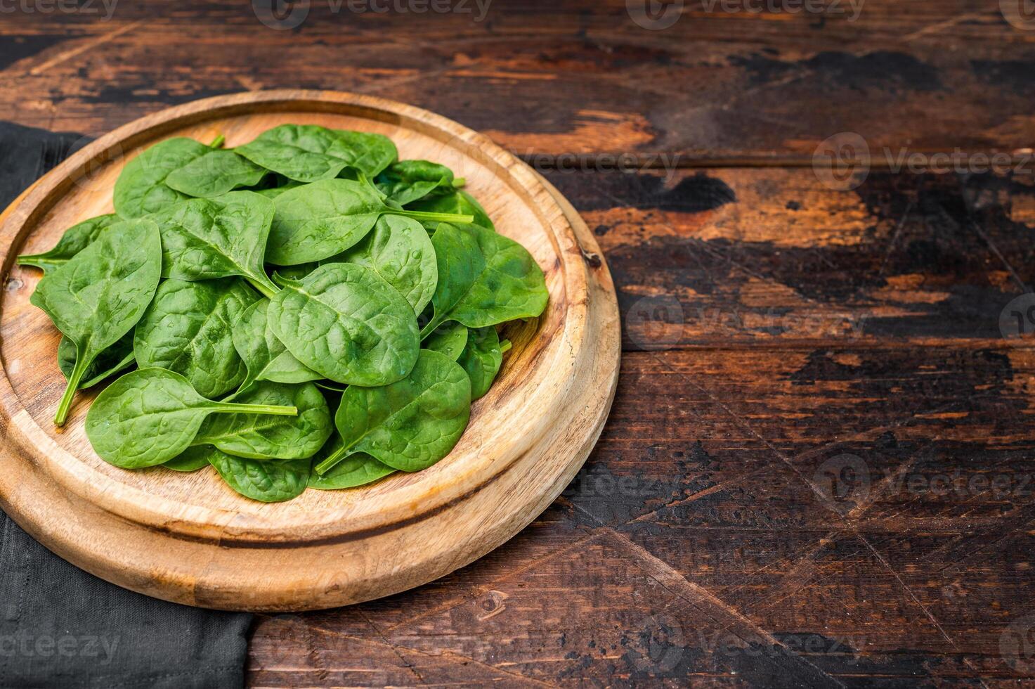 Close up of fresh spinach leaves showcasing their rich green color, ideal for nutritious dishes and salads. wooden background. top view photo
