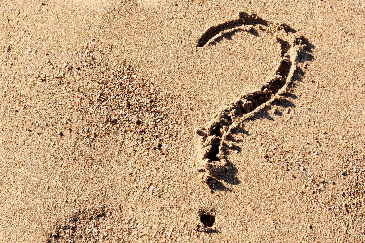 Question mark sign sand beach near sea. Concept of dilemma, answer and question photo
