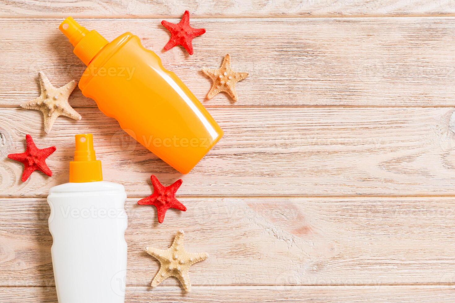 Sunscreen bottles seashells starfish on wooden table with copy space. flat lay concept of summer travel vacation photo