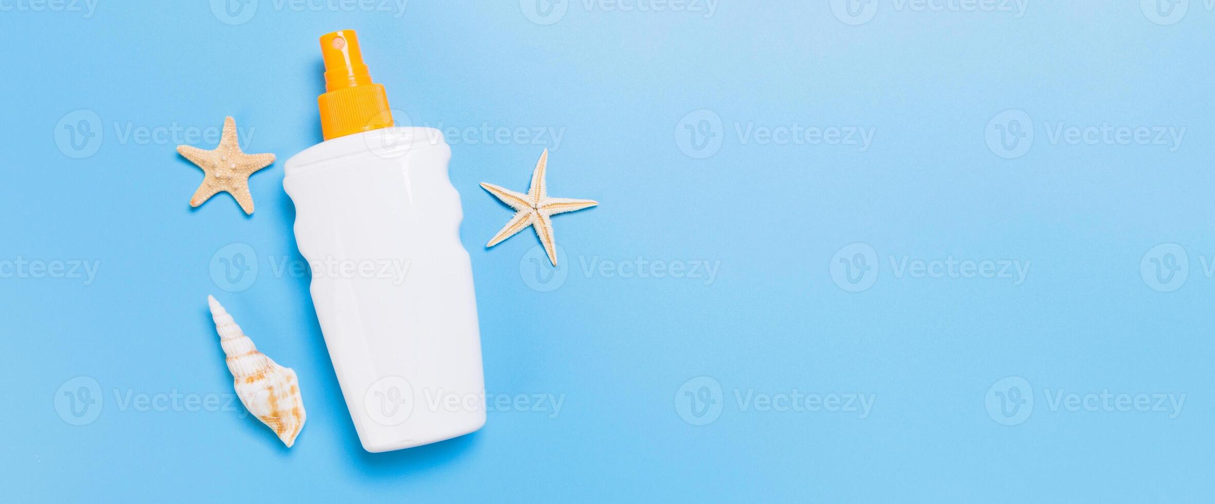 sunscreen cream banner with starfish and seashells in bottles on blue background, top view photo