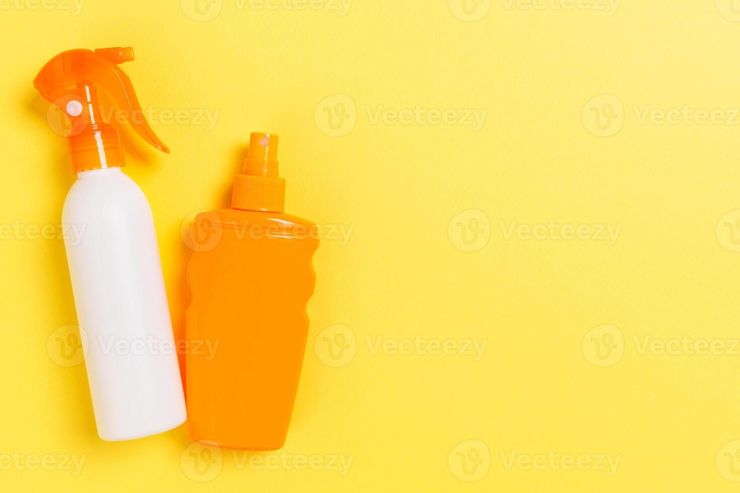 flat lay concept summer travel vacation. Sunscreen bottle mock up on yellow background with copy space photo