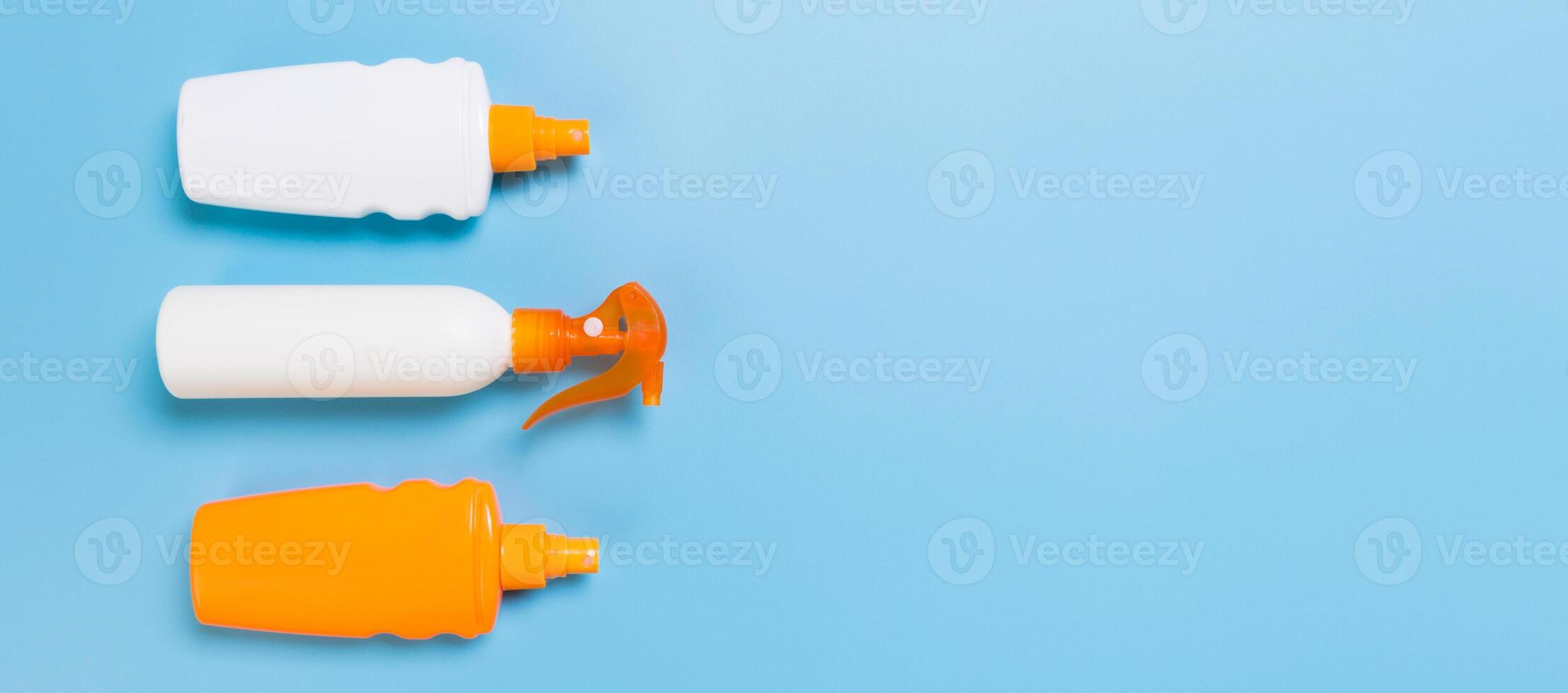 flat lay concept banner of summer travel vacation. Sunscreen bottle mock up on blue background top view with copy space photo