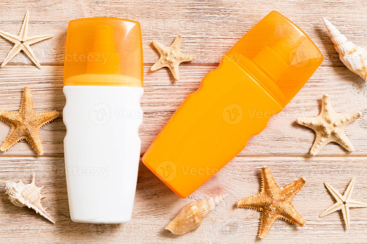 Sunscreen bottles seashells and starfish on wooden table flat lay concept summer travel vacation photo