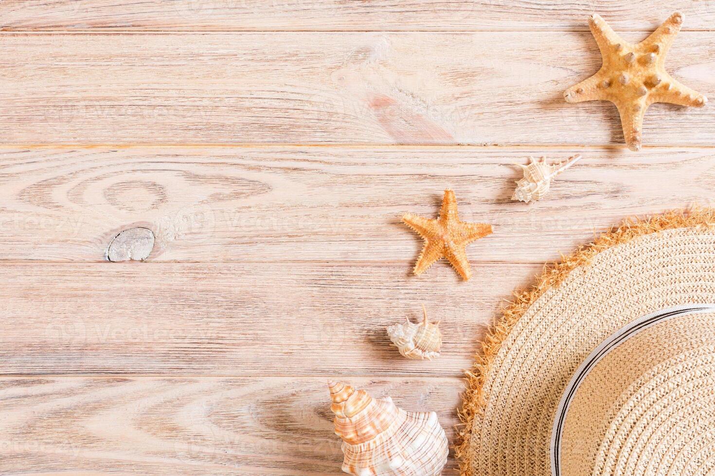 Beach hat with seashells brown wooden table. summer background concept with copy space photo