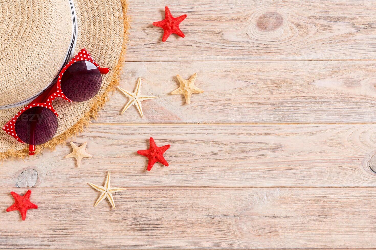 Summer holiday background straw hat and seashells wooden background top view with copy space photo