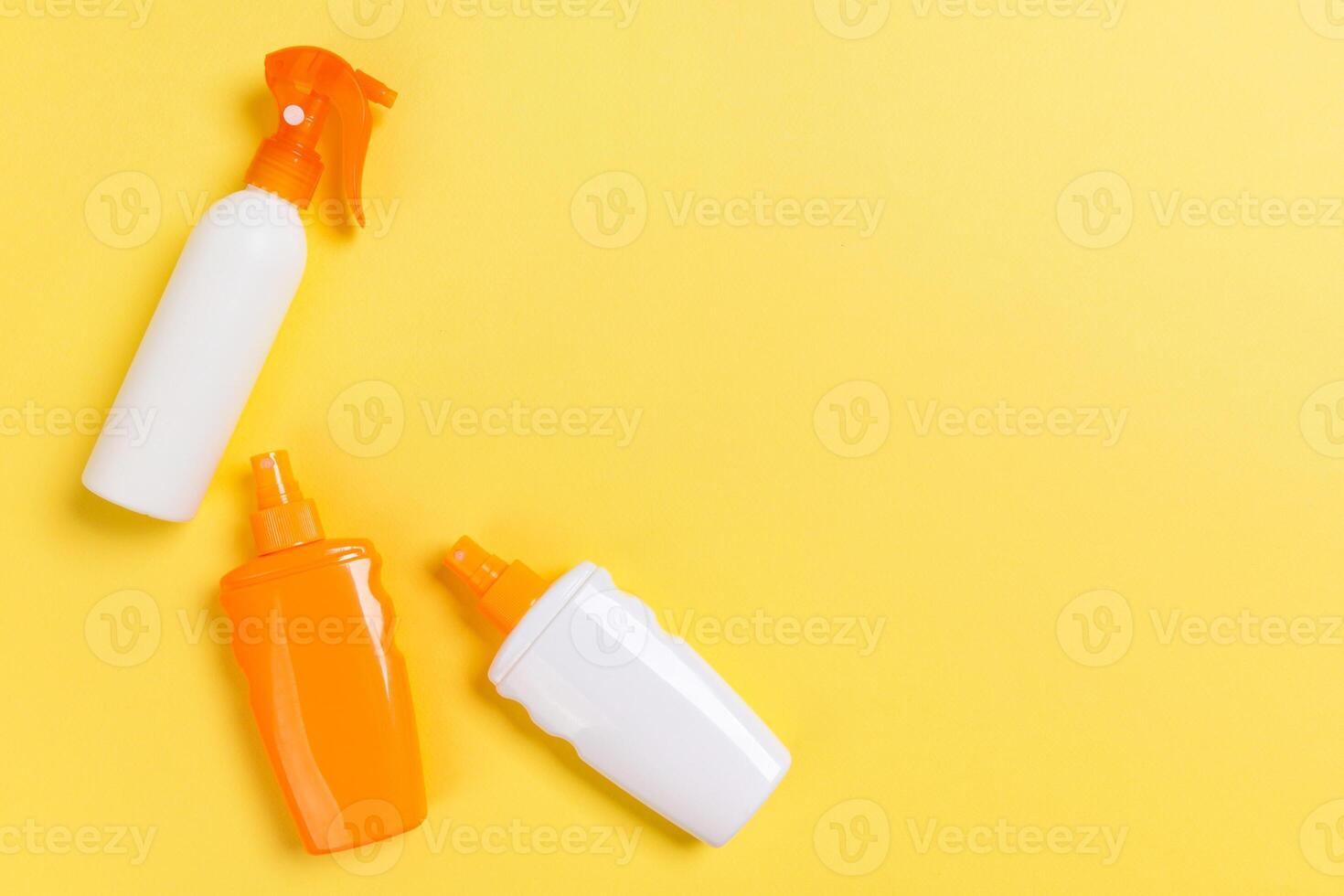flat lay concept summer travel vacation. Sunscreen bottle mock up yellow background top view with copy space photo