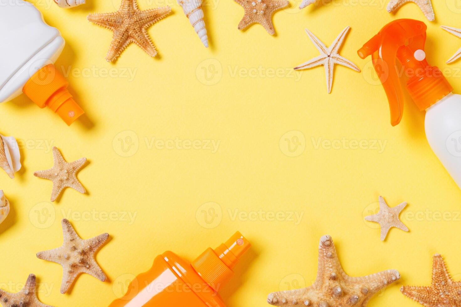 sunscreen cream with starfish and seashells bottles yellow background, top view photo