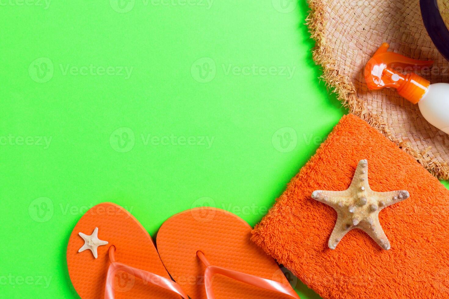 Summer beach flat lay accessories. Sunscreen bottle cream, straw hat, flip flops, towel and seashells colored Background. photo