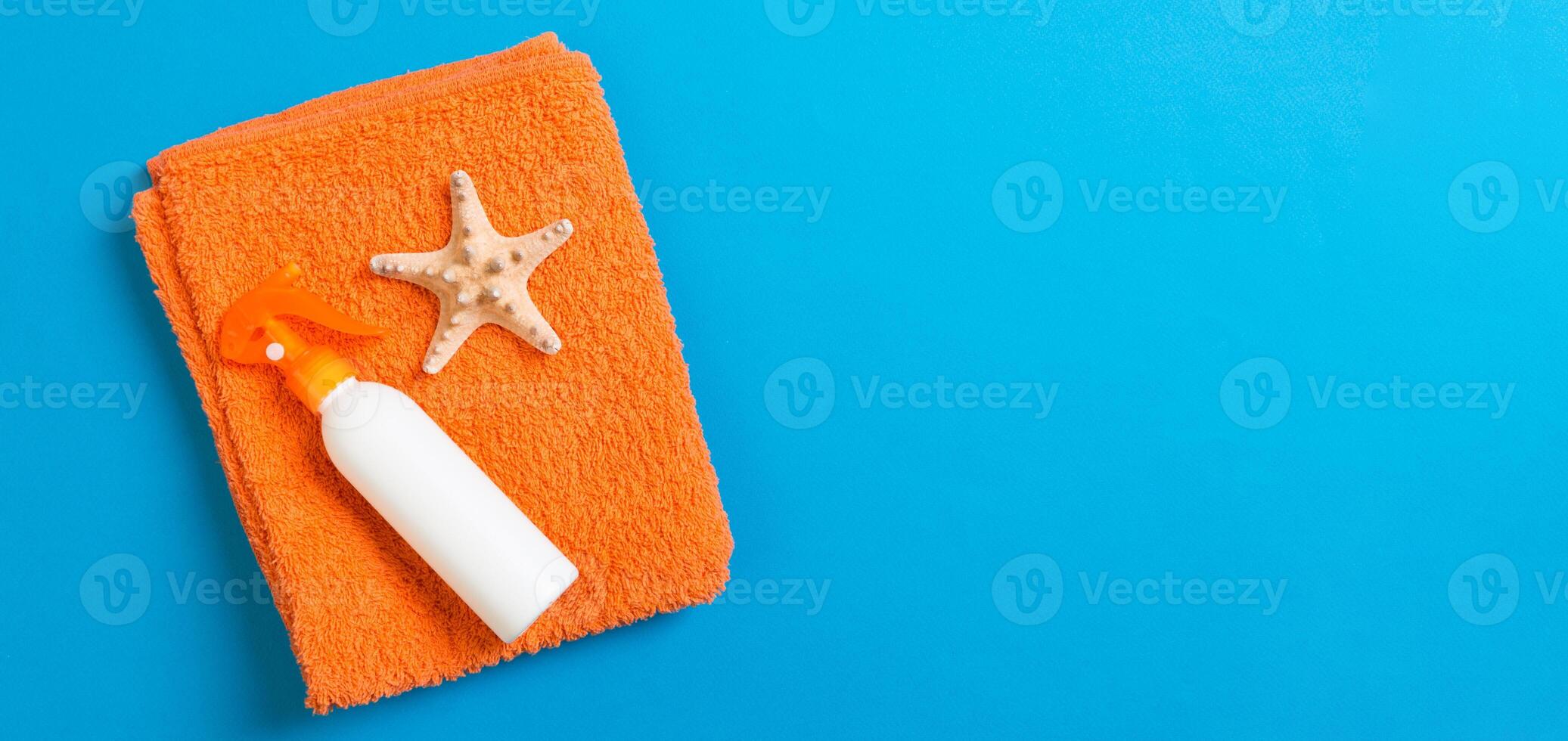Summer beach flat lay accessories. Sunscreen bottle cream, towel and seashells colored banner Background. Travel holiday concept with copy space photo