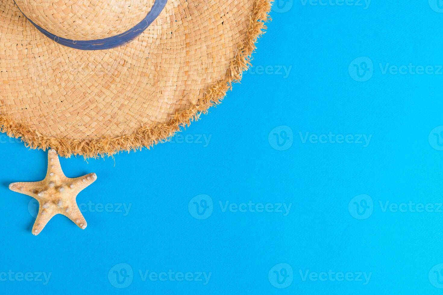 yellow retro straw hat with seastar top view with copy space. summer concept blue background photo