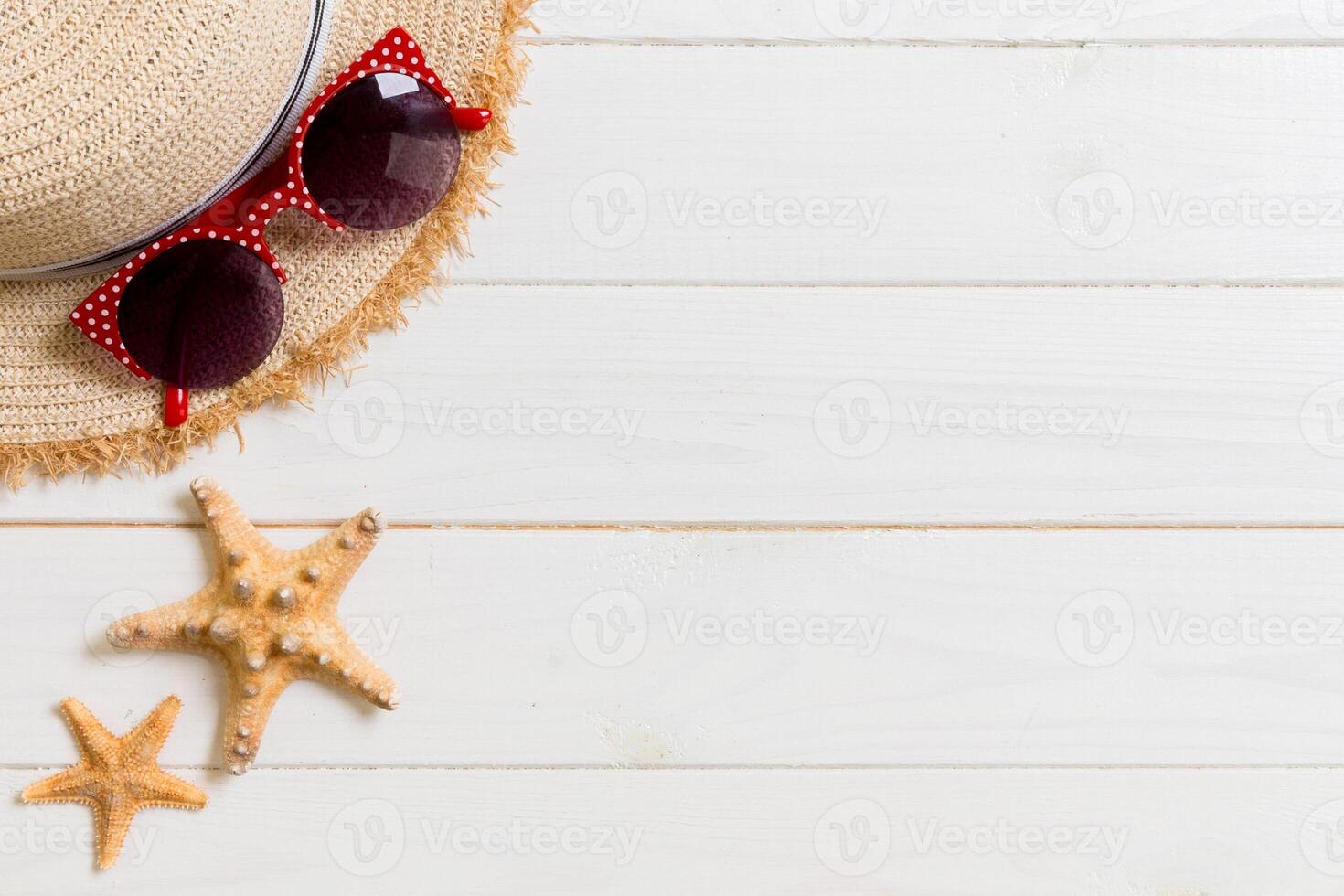 Straw hat, sun glasses and seashells on white wooden background. top view summer holiday concept with copy space photo
