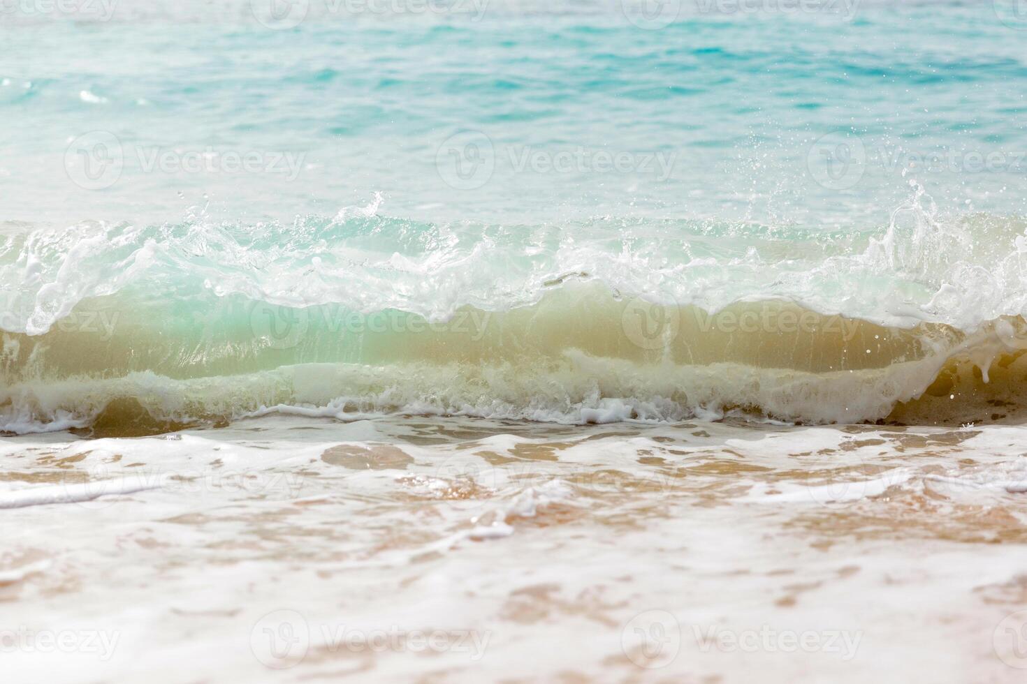 Close up sea waves with splashes on sand beach. photo