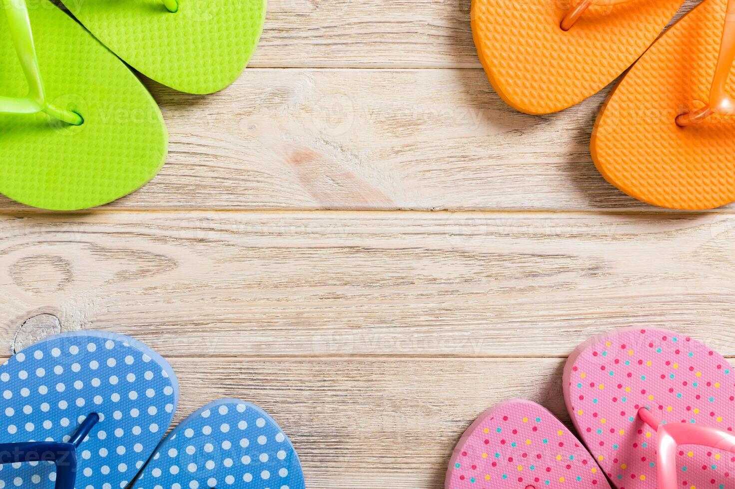 a lot flip flop colored sandals, summer vacation on wooden background, copy space top view photo