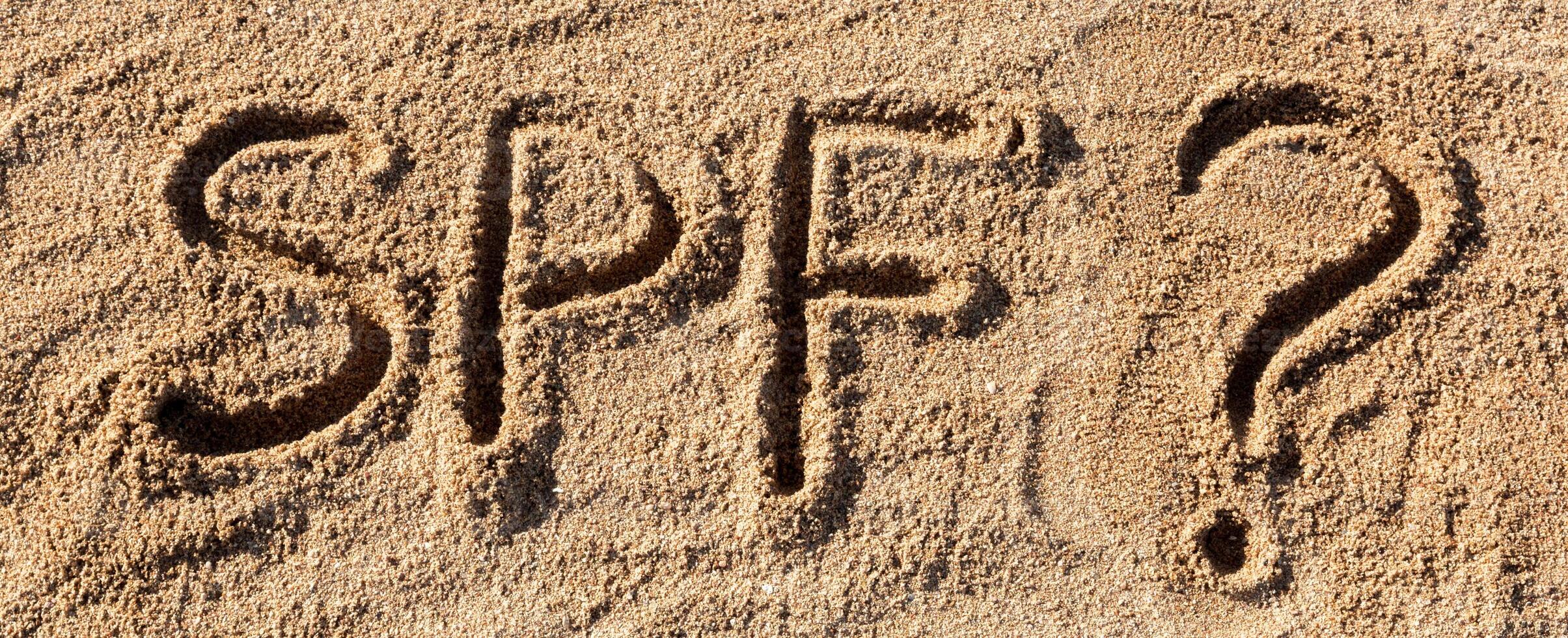 Sun protect factor concept. SPF word written beach with question mark photo