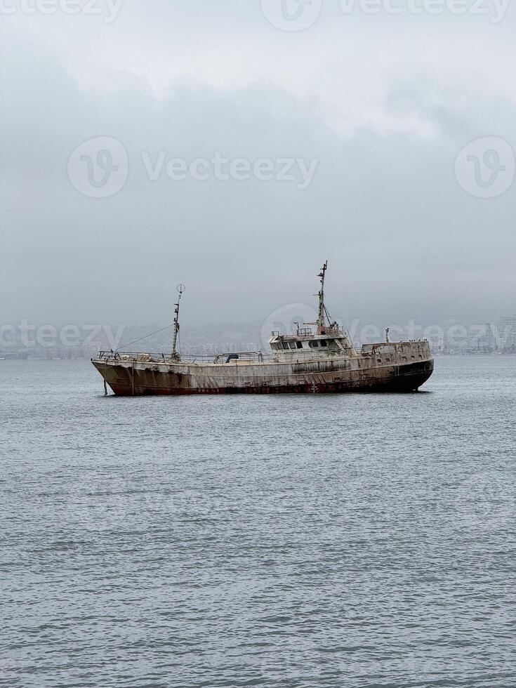 Abandoned Rusty Ship Floating in Foggy Coastal Waters photo