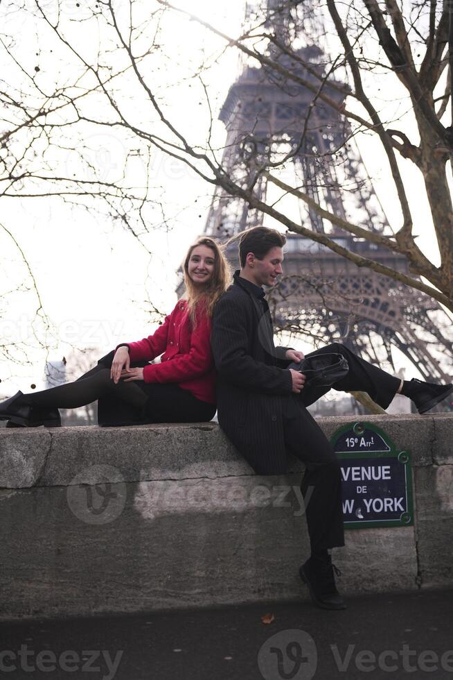 Smiling couple relaxes near Eiffel Tower in Paris photo