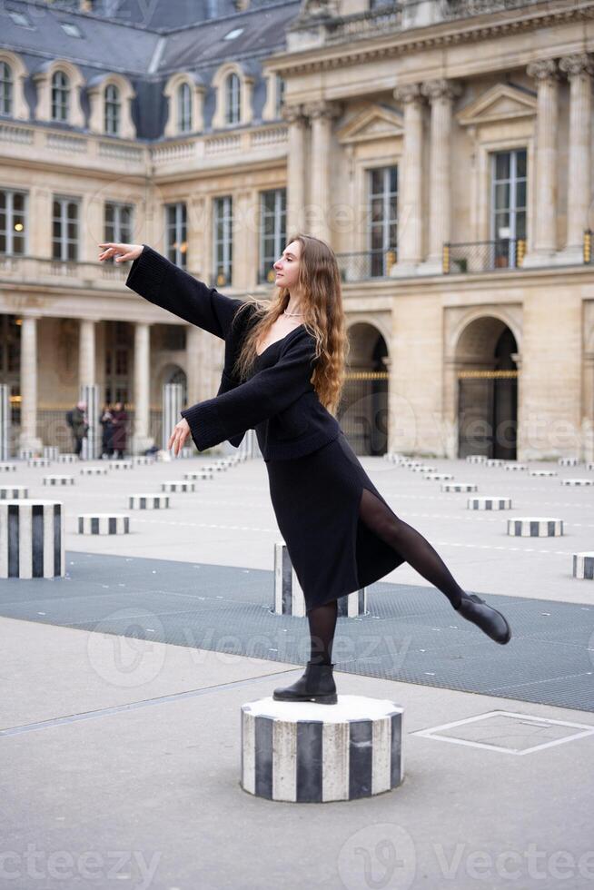 Graceful Woman Balancing on Column at Palais-Royal in Paris with Ballet Elegance photo