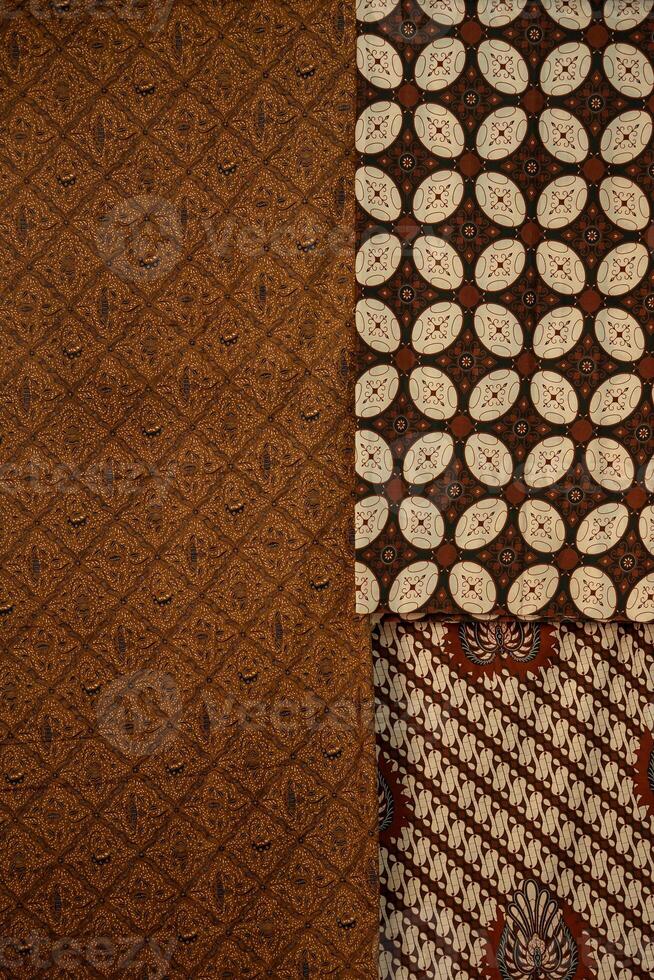 Traditional batik fabrics with intricate patterns in brown, beige, and black tones. Authentic Indonesian textile with cultural motifs, perfect for backgrounds and design elements. photo
