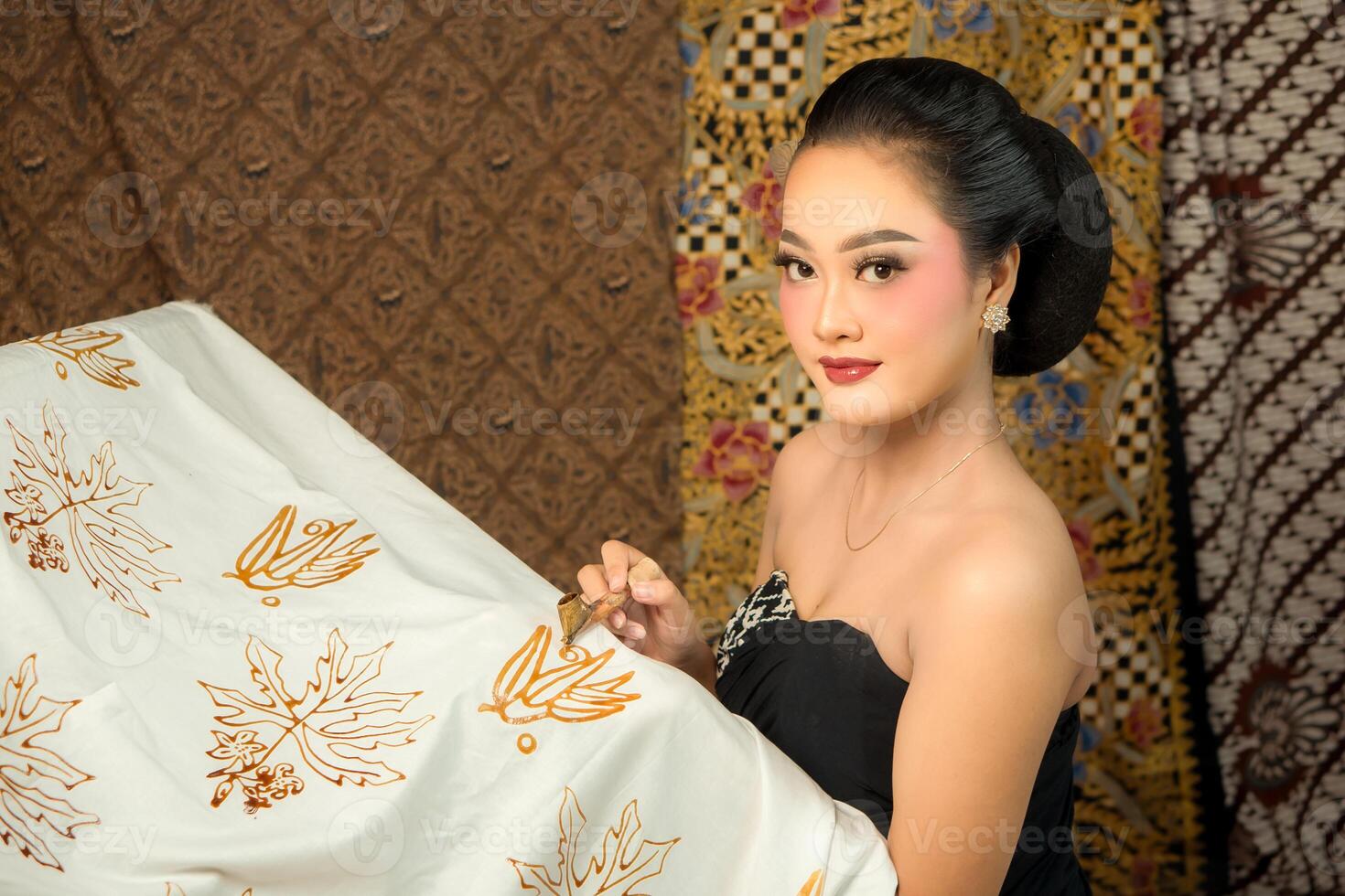 Indonesian woman creating batik with a canting, wearing traditional attire. Elegant look, rich cultural heritage, and intricate patterns. Artistic craftsmanship Southeast Asian textile art photo