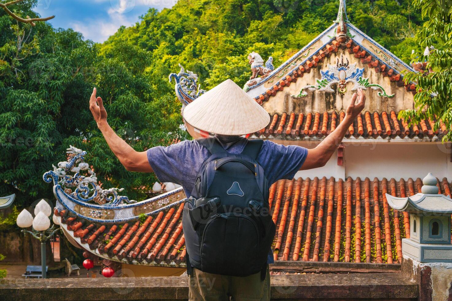 back of a male tourist traveler at temple on the Buddhist pagoda in Da Nang, Vietnam. Travel and tourism in Asia photo