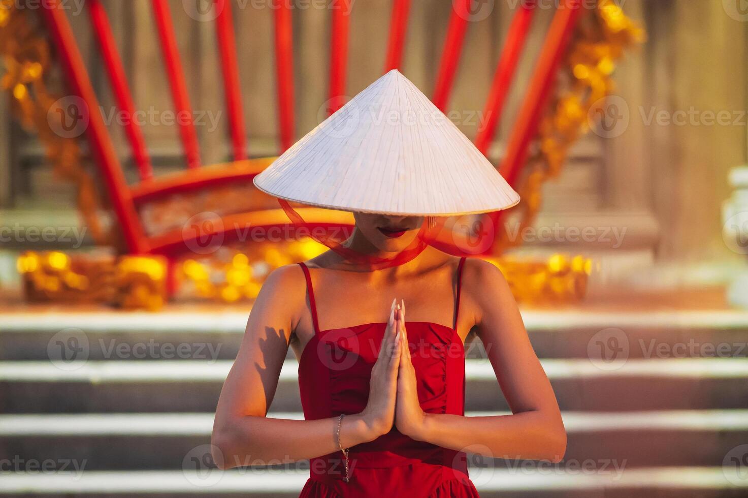 woman in traditional Vietnamese Non La hat prays at a temple on a Buddhist pagoda in Vietnam. The concept of travel in Asia photo