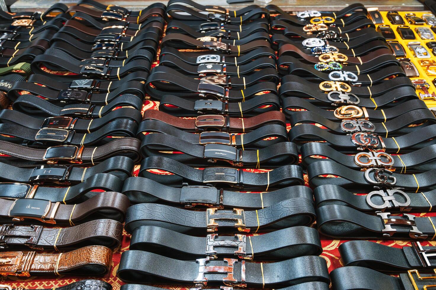 Genuine leather men's belts on counter in the Asian market. Da Nang, Vietnam - November 29, 2024 photo