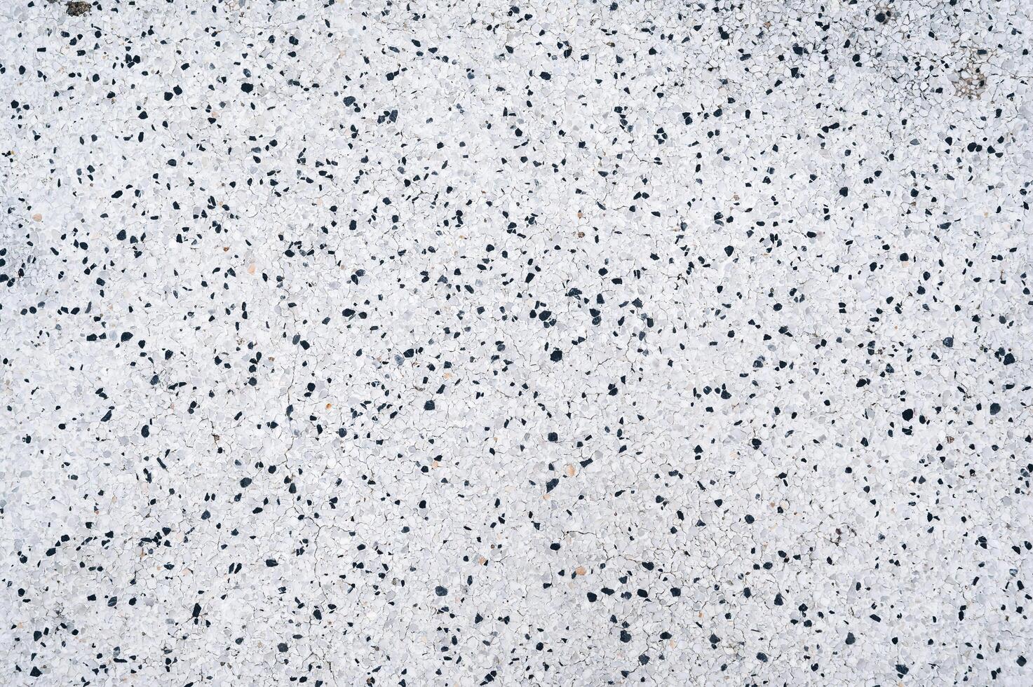 white background texture with pattern of black stones on paving slabs photo