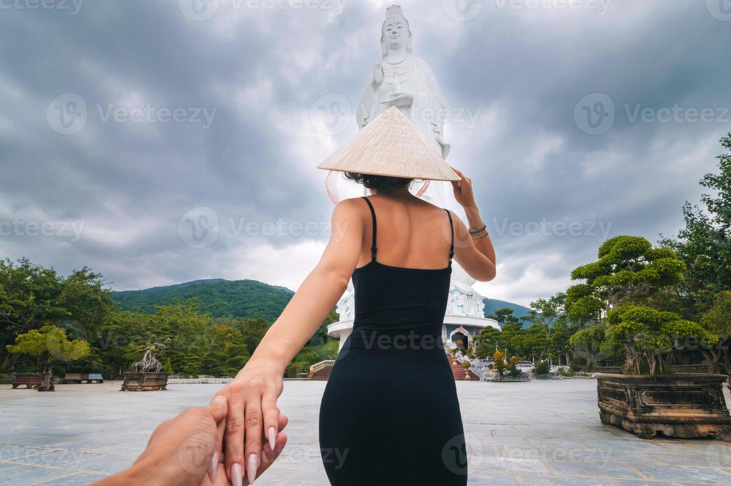 back of girl tourist traveler at Lady Buddha statue at Linh Ung Pagoda in Da Nang in Vietnam. Follow me concept of travel and tourism in Asia photo