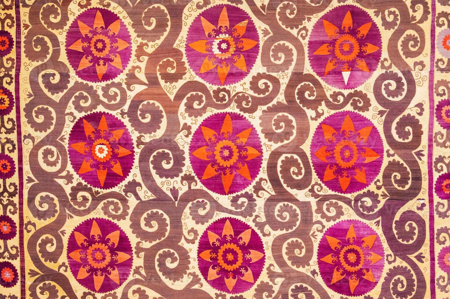 traditional Uzbek pattern on ancient handmade carpet in Uzbekistan. Oriental background with beautiful ornaments photo