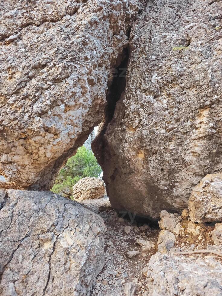 Hiking trail through a narrow manhole in granite rocks photo