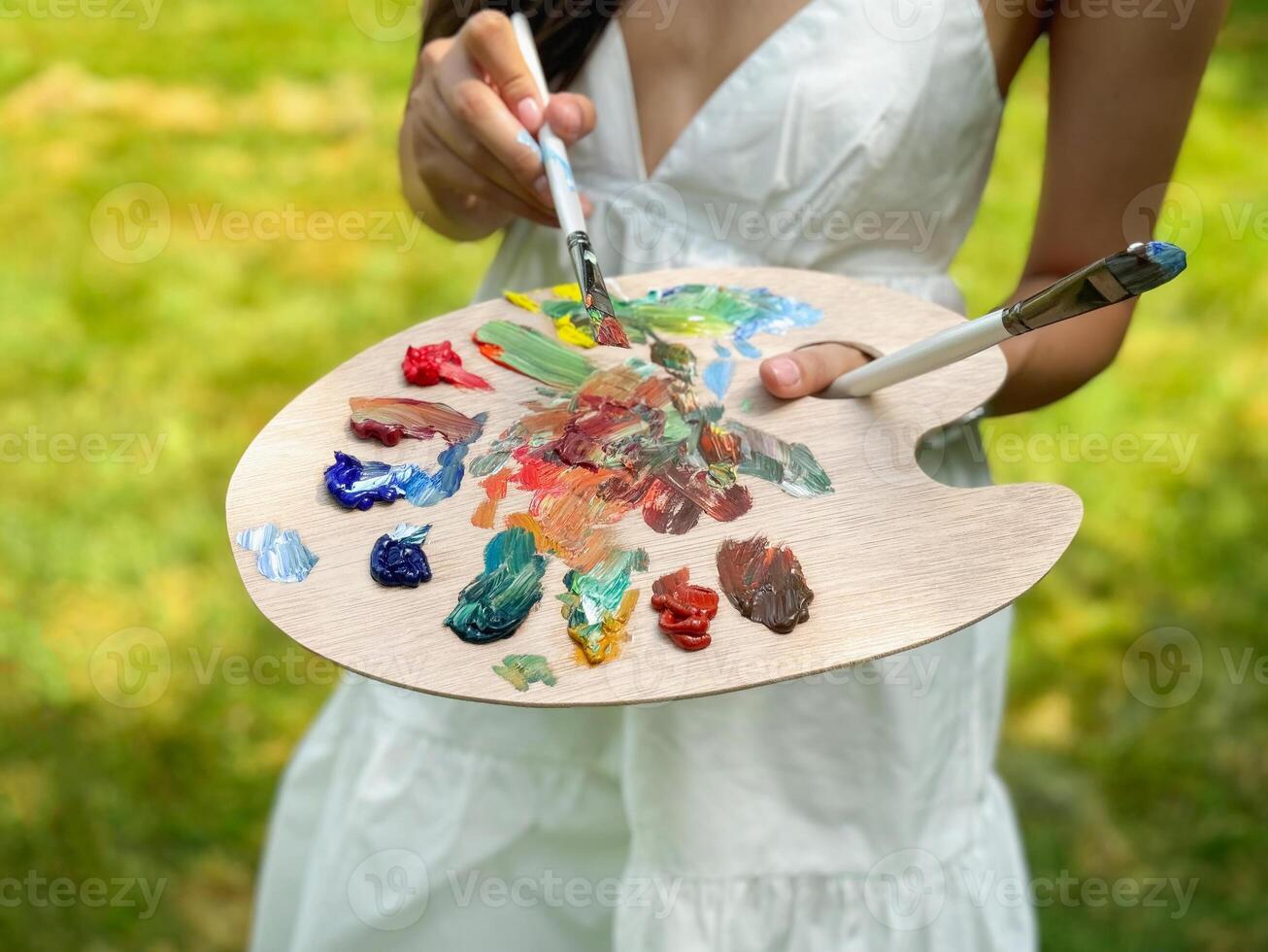 palette of paints and brushes in your hands photo
